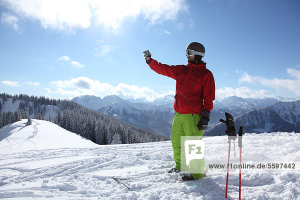 Skier taking photograph of scenery