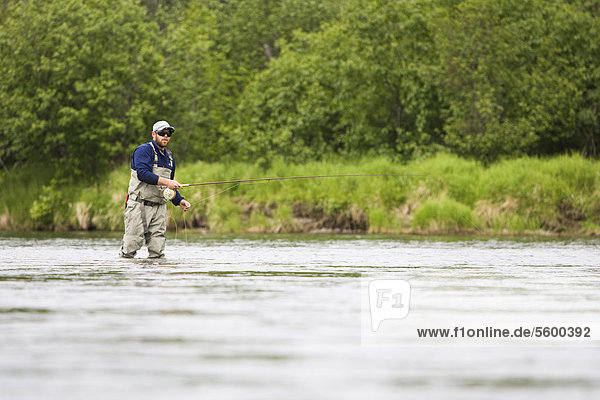 A sportfisherman fishing for salmon on the Mulchatna River in the Bristol Bay region  Southwest Alaska  Summer