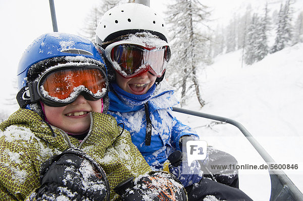 Snow-covered children in ski lift