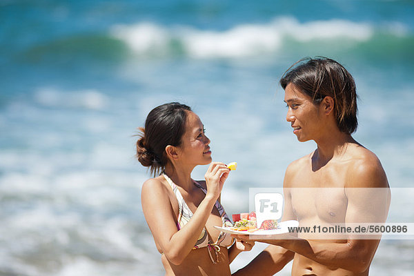 Couple eating together on beach