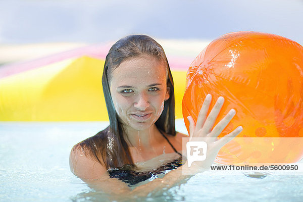 Girl holding inflatable toys in pool