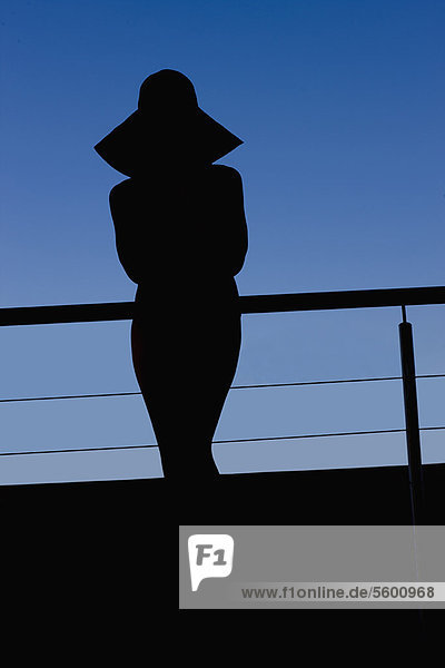 Silhouette of woman in sunhat outdoors