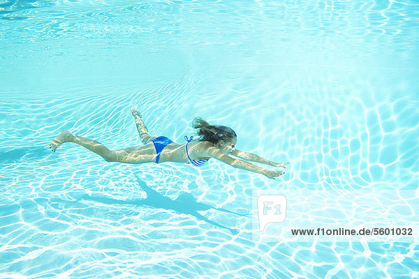 Frau im Bikini schwimmt im Pool
