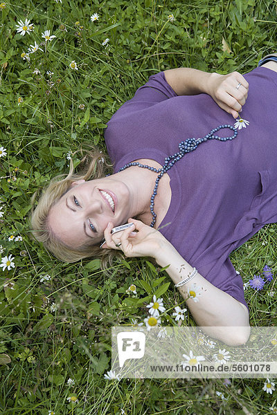 Woman talking on cell phone in grass
