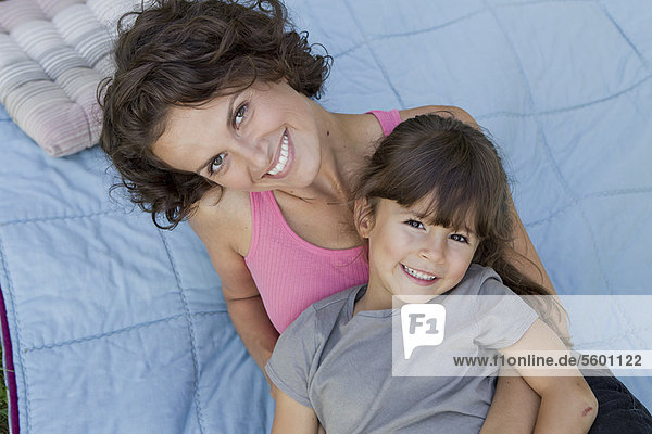 Mother and daughter relaxing on blanket