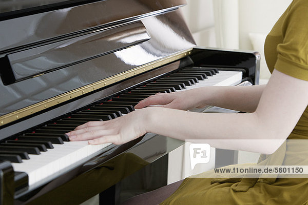 Close up of teenage girl playing piano