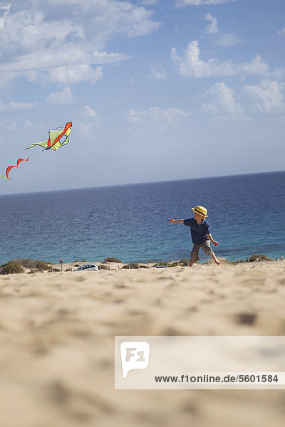 Boy flying kite on beach