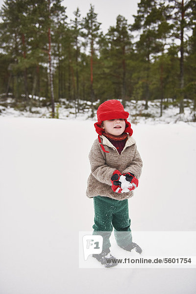 Junge spielt im Schnee im Freien