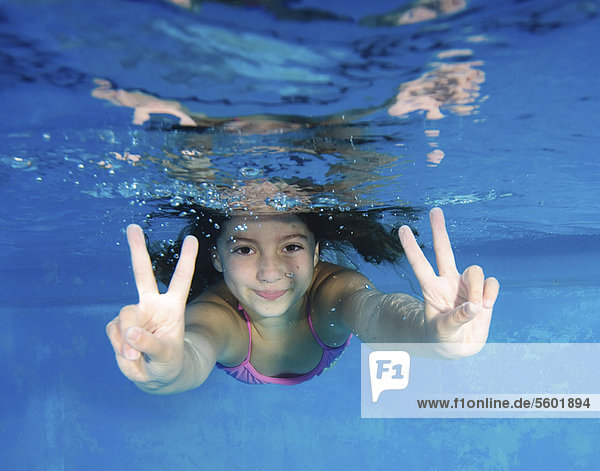 Lächelndes Mädchen spielt im Schwimmbad