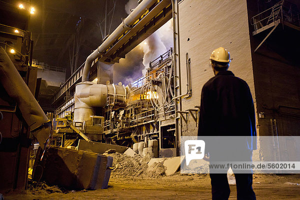 Worker walking in steel forge