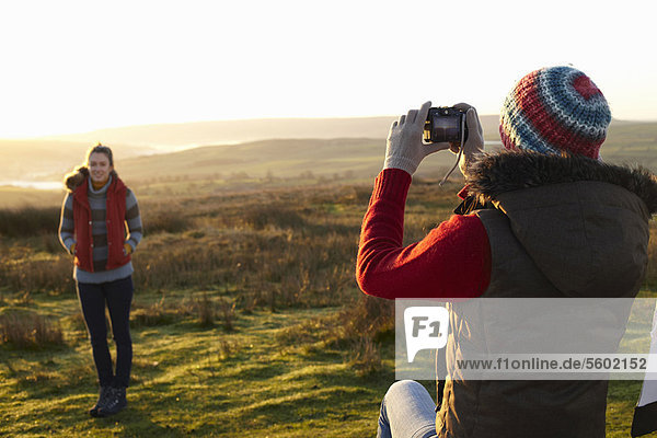 Woman taking picture of friend outdoors
