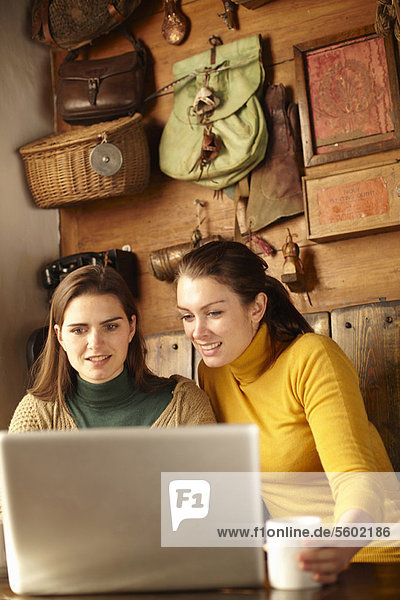 Women using laptop in cafe