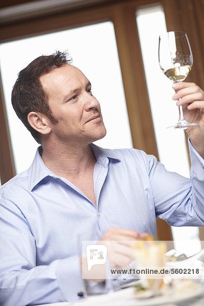 Businessman examining glass of wine