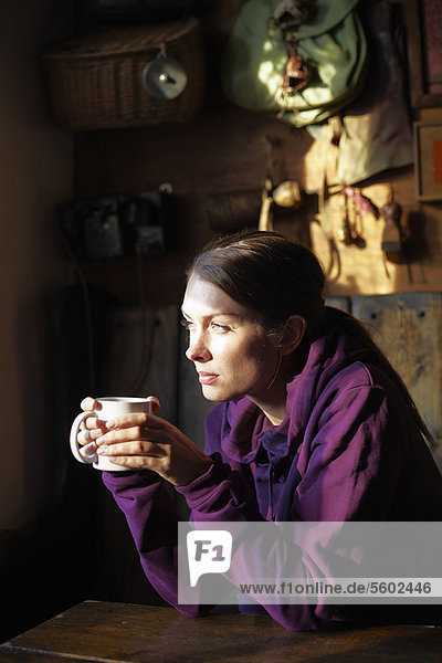 Woman drinking cup of coffee in cafe