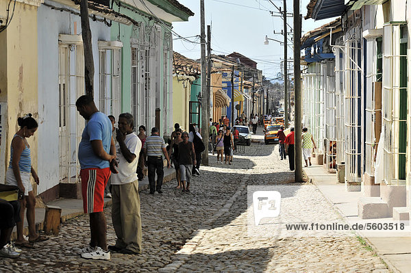 Cubans standing in a side street  cobbled street  old town  Trinidad  Cuba  Greater Antilles  Caribbean  Central America  America