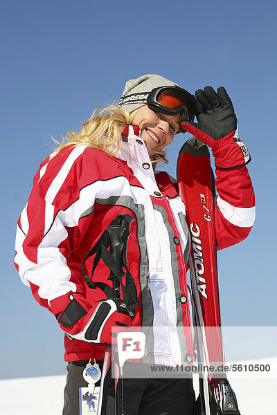 junge Frau junge Frauen Europa lächeln Beleuchtung Licht Himmel Mütze weiß blau Ski rot 1 Kleidung Deutschland grau Thüringen