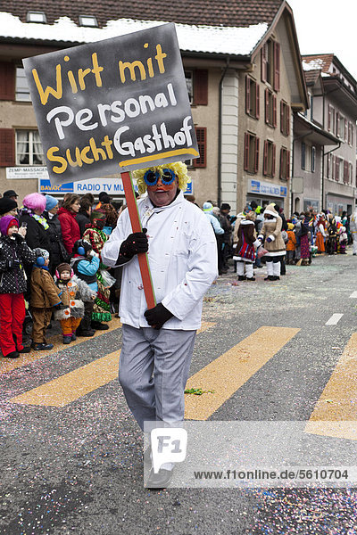 'Parade participant carrying a sign lettering ''Wirt mit Personal sucht Gasthof''  German for ''publican and staff looking for a pub''  35th Motteri-Umzug parade in Malters  Lucerne  Switzerland  Europe'