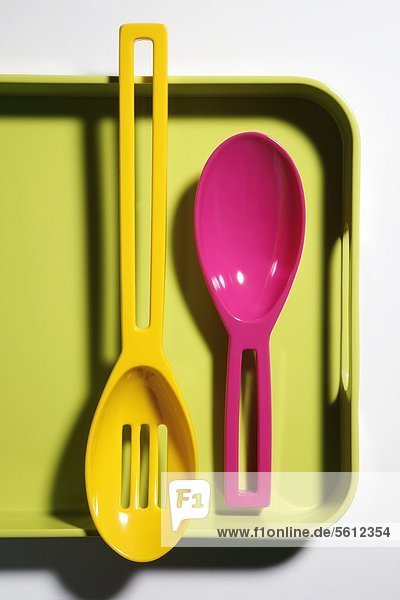 Two plastic spoons on plastic tray