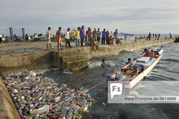 Fishermen landing their catch  taking it to the quay walls  floating plastic debris at front  Kota Biak  Biak Island  Irian Jaya  Indonesia  Southeast Asia  Asia