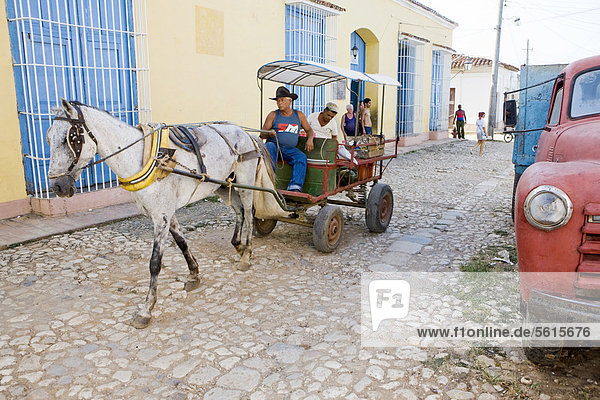 A horse cart and an old red truck in the historic district  Trinidad  Cuba  Central America
