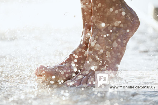 Füße unter der Dusche im Freien