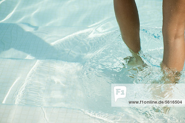 Woman wading in pool  cropped