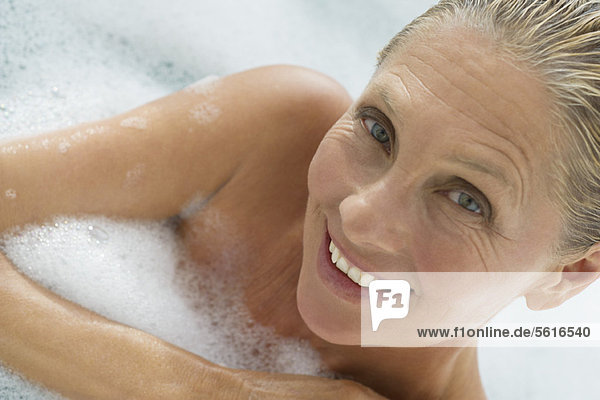 Mature woman enjoying bubble bath  tilt