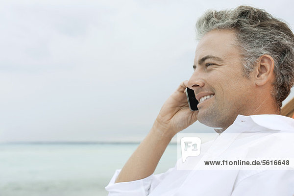 Man talking on cell phone at the beach
