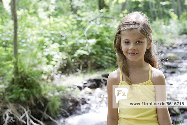 Girl by stream in woods  portrait
