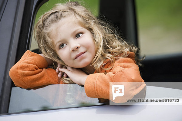 Kleines Mädchen aus dem Autofenster gelehnt  Tagträumen  Portrait
