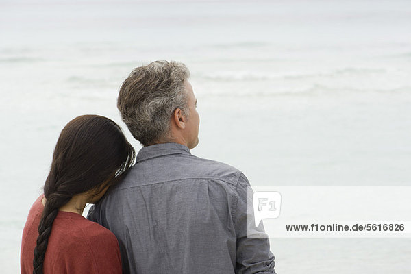 Couple looking at sea together  rear view