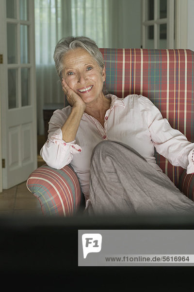 Smiling senior woman sitting in armchair