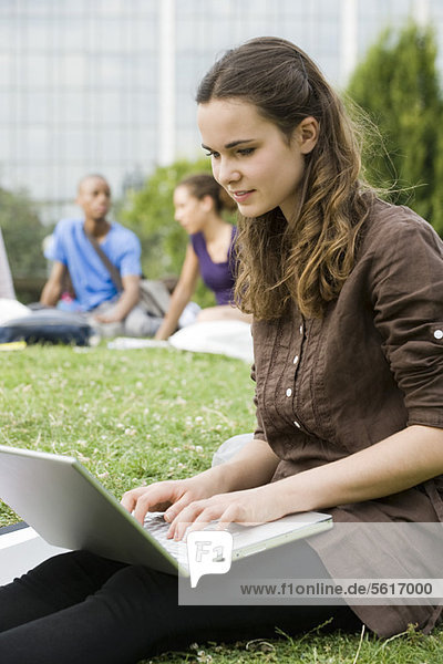 Junge Frau mit Laptop im Freien  Menschen im Hintergrund  Portrait