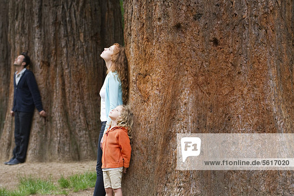 Mutter und Tochter lehnen sich an den Baumstamm und atmen frische Luft.