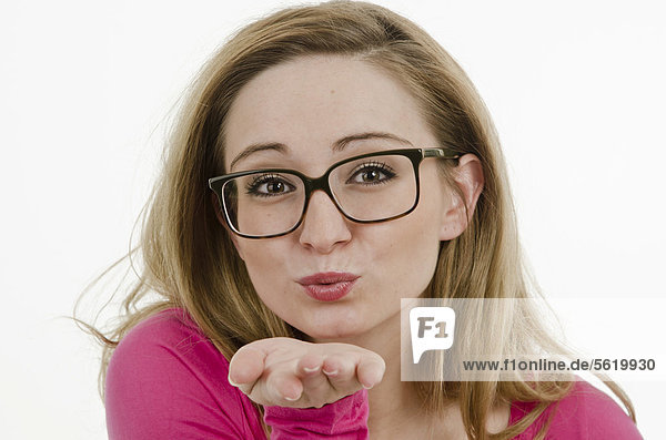 Junge Frau  25 Jahre  mit großer Brille  gibt Luftkuss