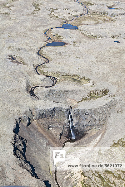 Luftaufnahme  ein mäandernder Fluss der in einem Wasserfall in eine Schlucht stürzt  auf einer wüstenähnlichen Hochebene im Westen von Island  Europa