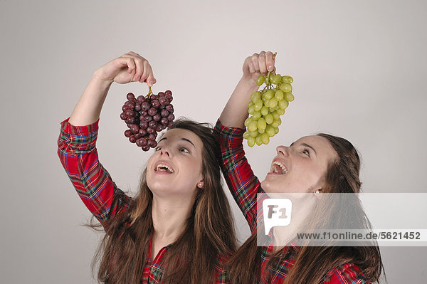 Zwillingsschwestern mit Weintrauben
