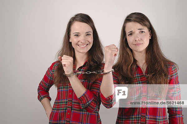 Zwillingsschwestern  mit Handschellen aneinander gekettet