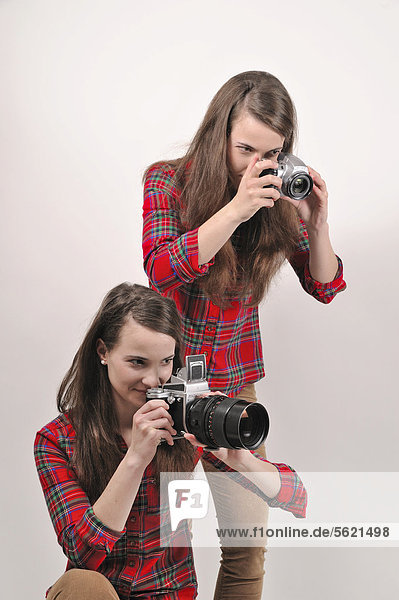 Zwillingsschwestern mit Kameras  eine mit Pentacon Six Mittelformat Analogkamera  die andere mit einer Digitalkamera