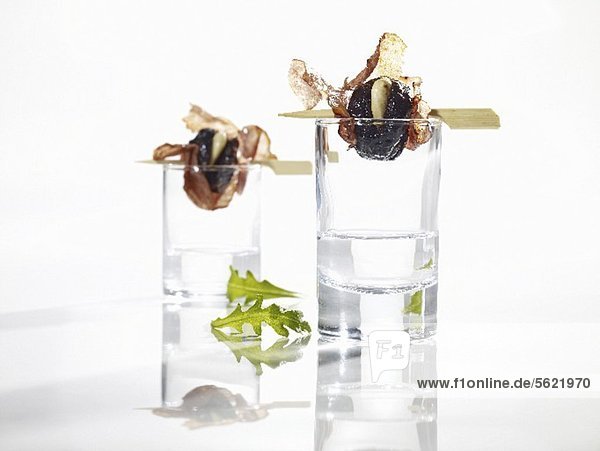 Gegrillte Pflaumen im Salamimantel auf Schnapsgläsern