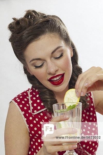 Mädchen im Retro-Look trinkt Zitronenlimonade