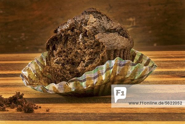 Chocolatechip Muffin im Papierförmchen  angebissen