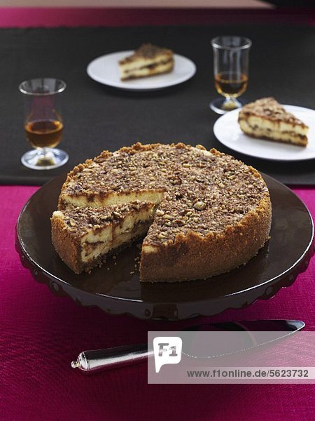 Praline cheese cake on a cake platter with a pie slice