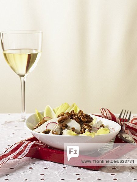 Winter salad with chicory  radishes and nuts and a glass of white wine