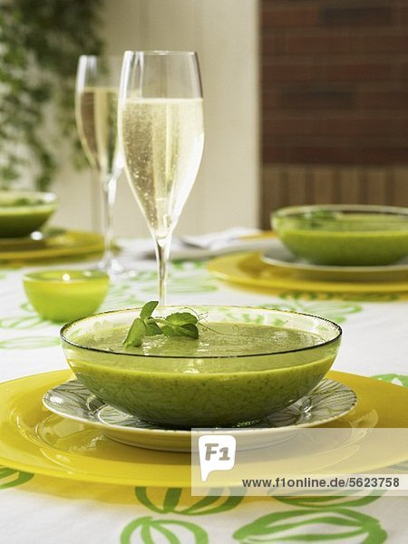Cream of pea soup with a glass of champagne