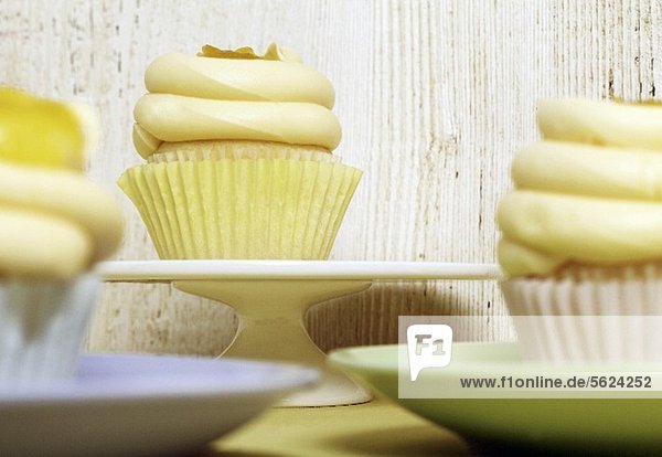 Frosted Cupcakes with Lemon Curd  On Blue  Green and White Plates