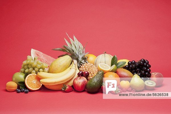 Verschiedene Früchte vor rotem Hintergrund