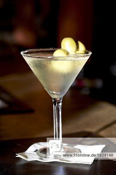 Martini im Glas mit grünen Oliven