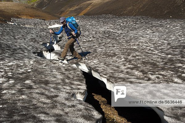 Wanderin geht über ein Schneebrett am Wanderweg Laugavegur  Hrafntinnusker-¡lftavatn  Fjallabak Naturschutzgebiet  Hochland  Island  Europa