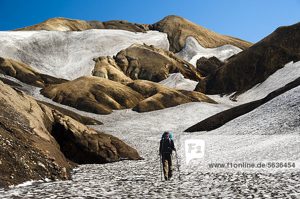 Wanderin  mit Schnee und Asche bedeckte Rhyolith-Berge und Schneefelder am Wanderweg Laugavegur  Hrafntinnusker-¡lftavatn  Fjallabak Naturschutzgebiet  Hochland  Island  Europa